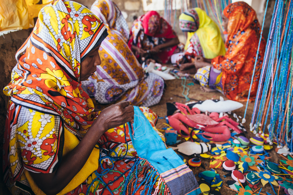 vrouwen zitten op grond in kleurrijke kleding