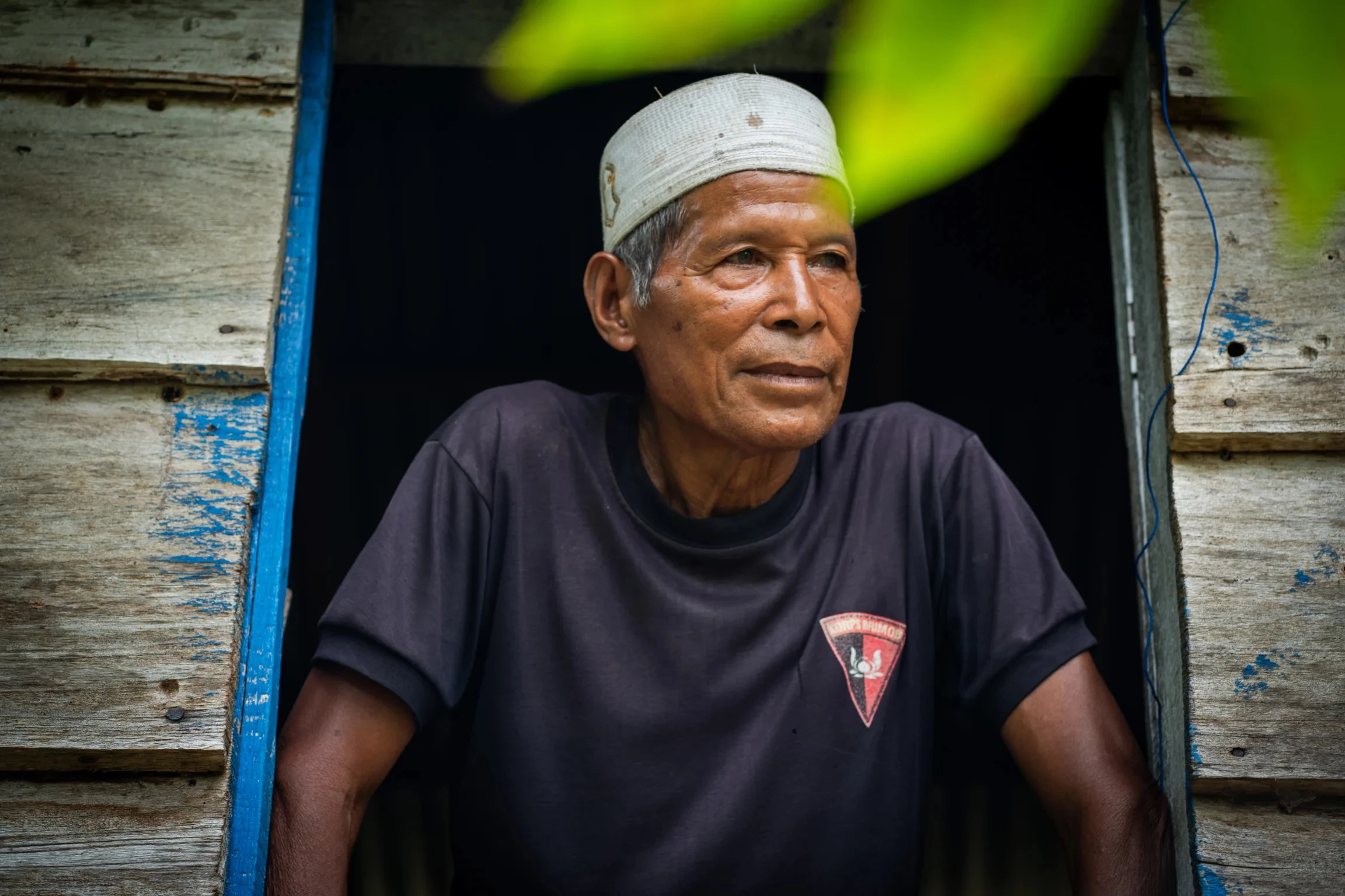 Mohammed Rasyid kijkend uit raam