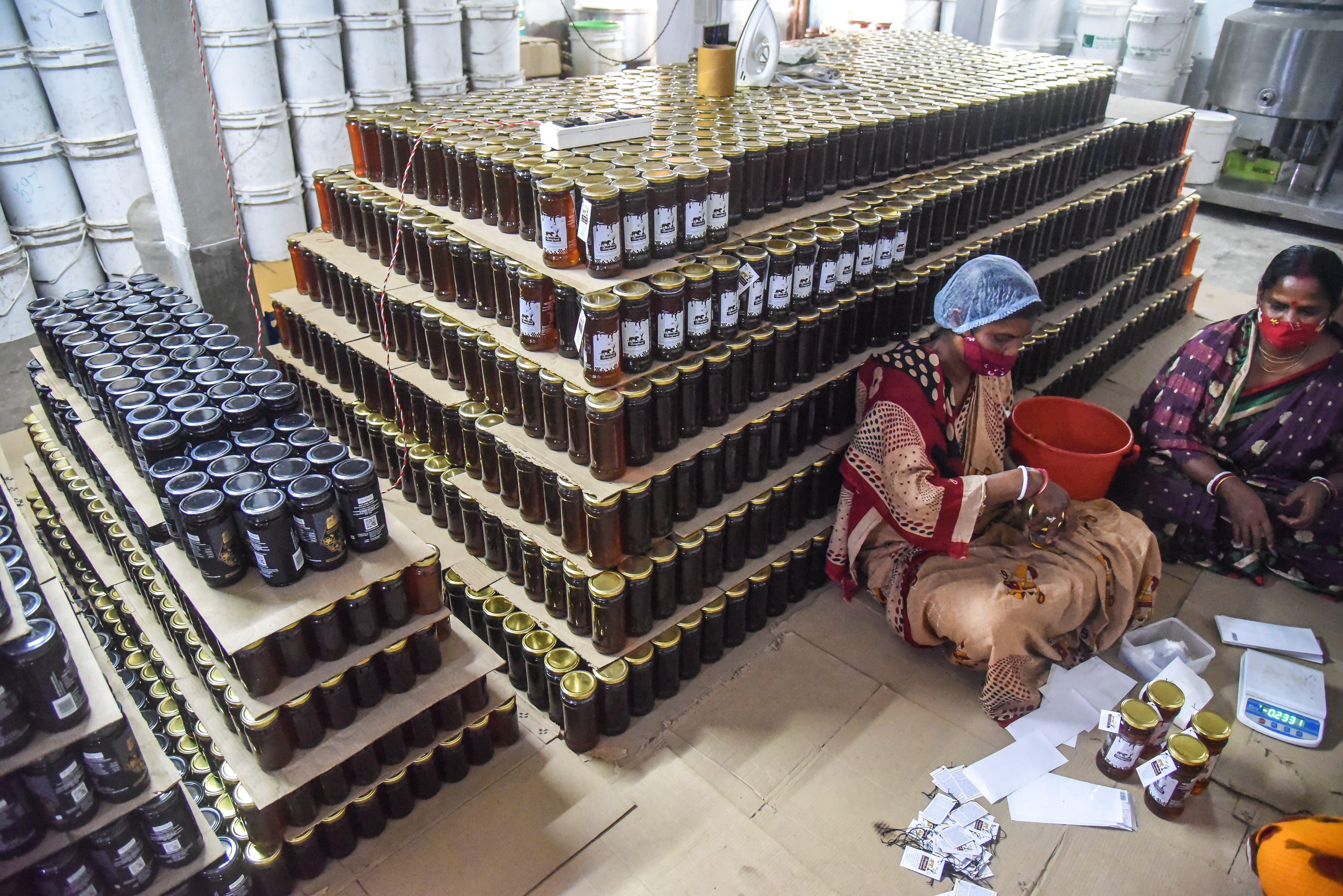 Etiketten plakken op potjes honing
