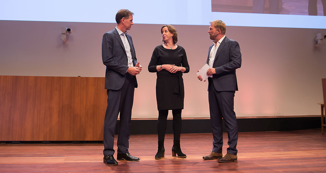 WNF congres met directeur Kirsten en twee mannen op het podium