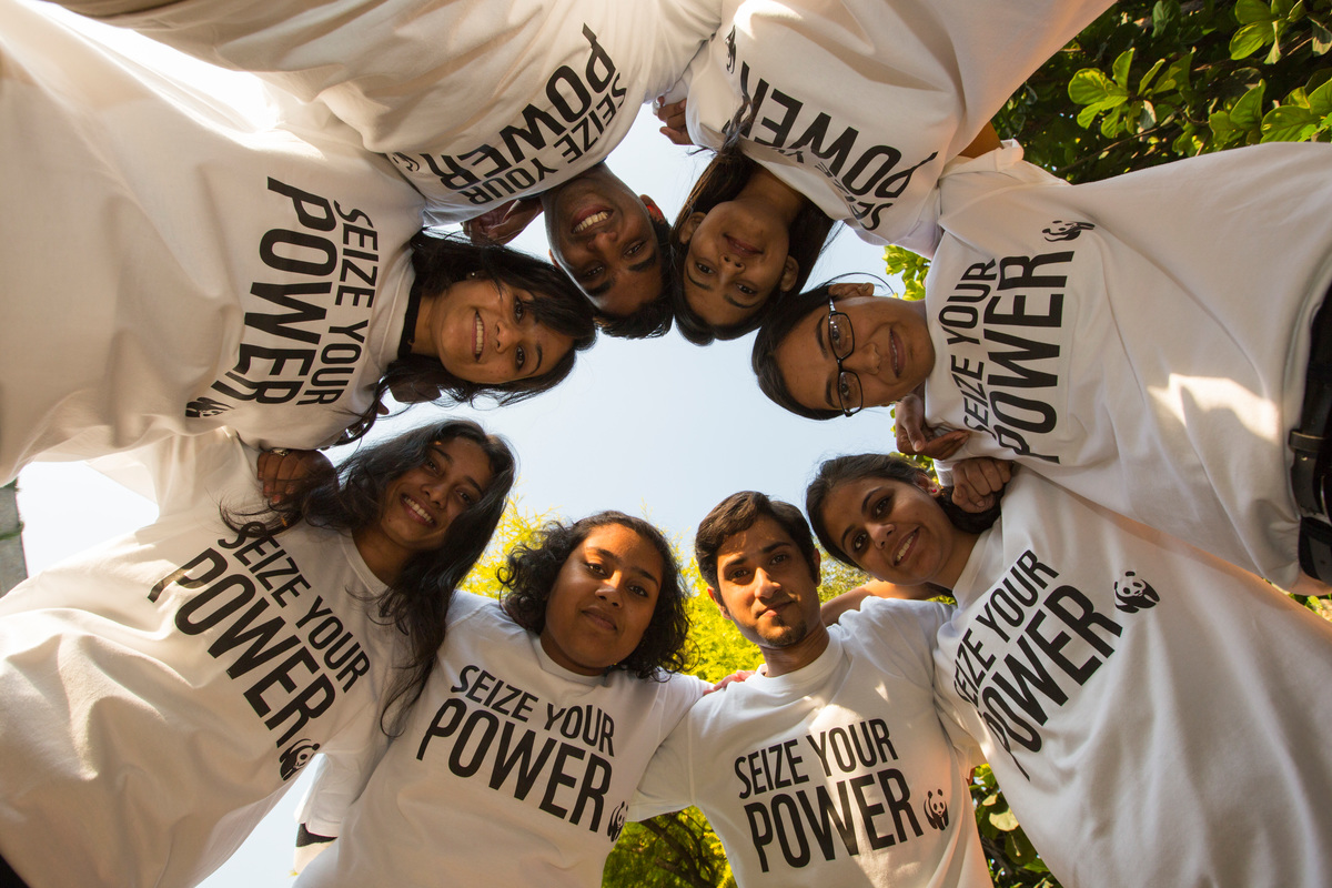 groep mensen staan in kring met dezelfde tshirts aan