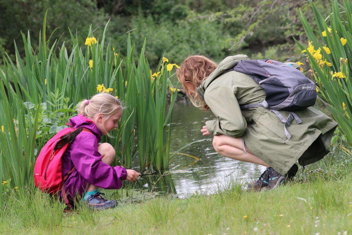 Volwassene en kind kijkend naar water.