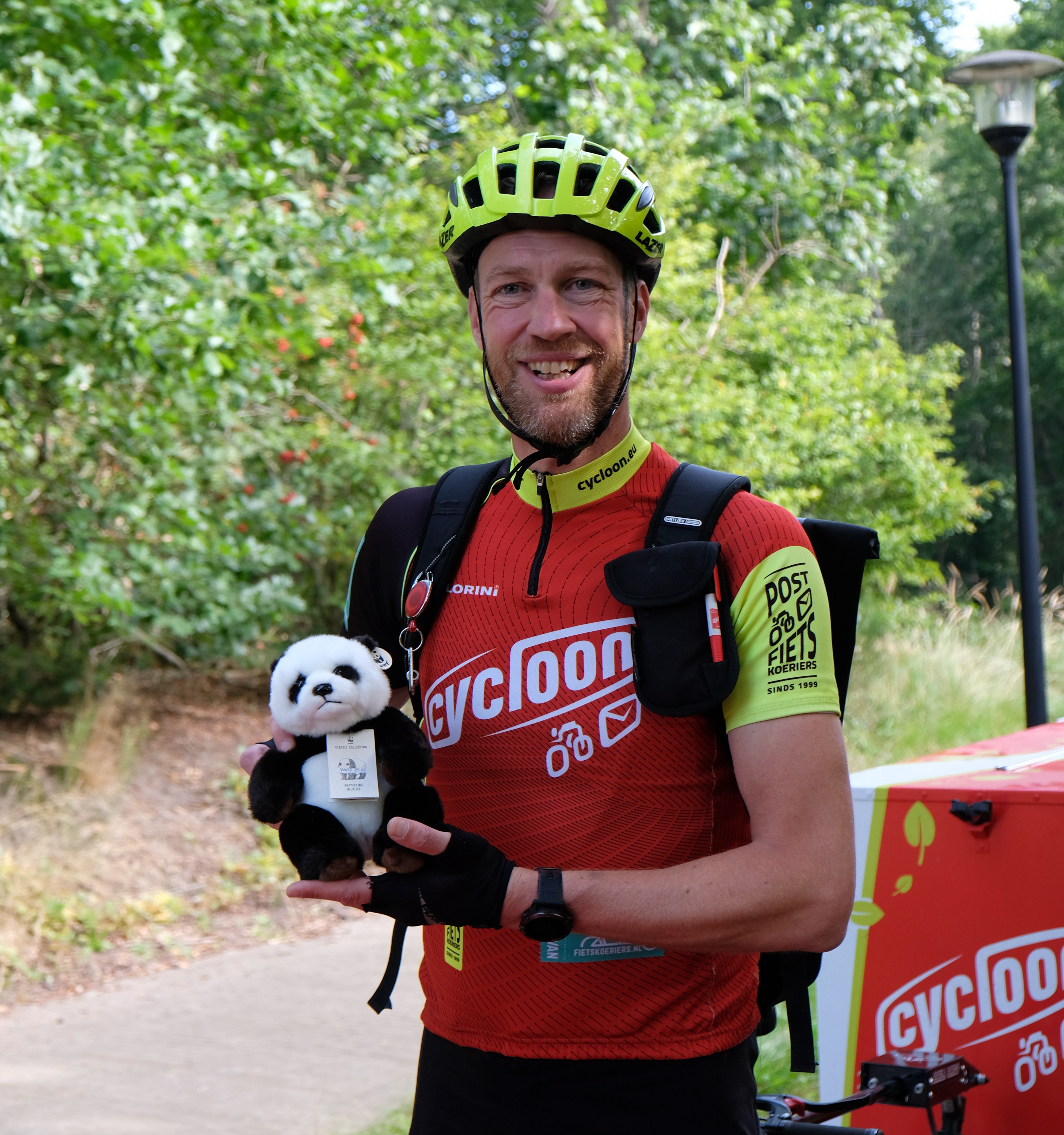 Een fietskoerier met een panda-knuffel