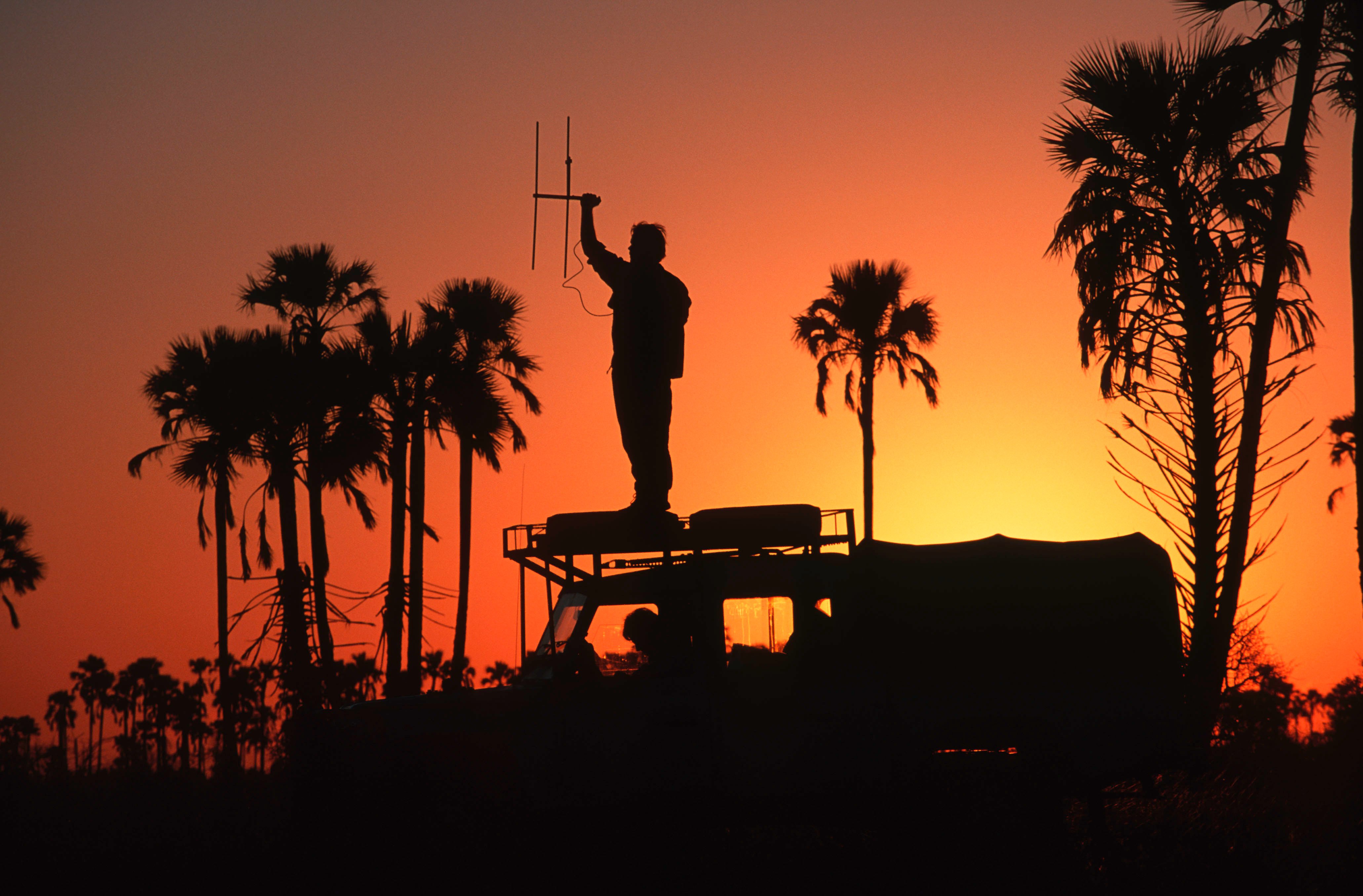 Man houdt onderzoeksapparaat vast en staat op een auto