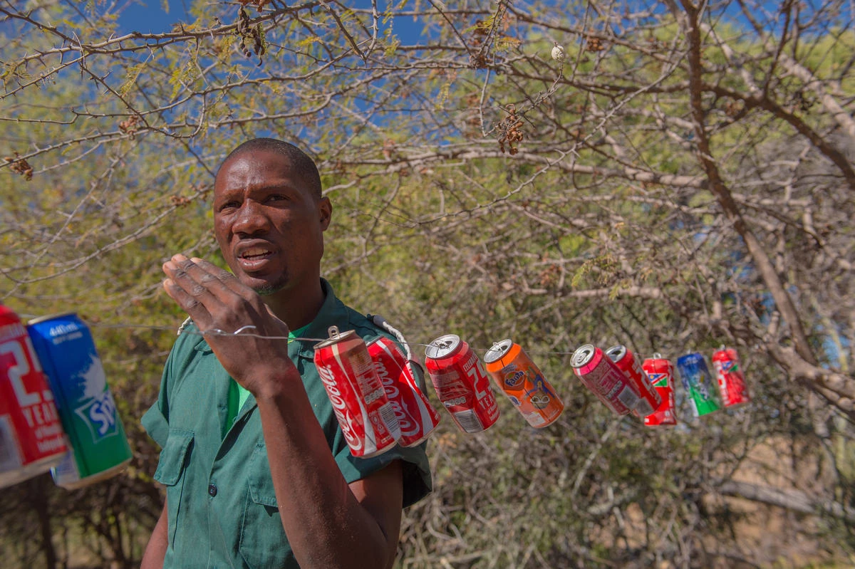 Humphrey Mwanga, een ranger in Wuparo Conservancy, Namibië, legt uit hoe blikjes olifanten op afstand houden